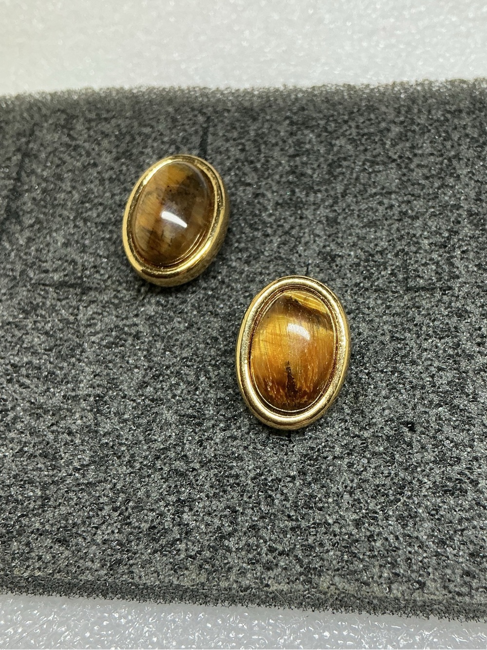 gold-tone stud earrings featuring polished oval Tiger’s Eye cabochons